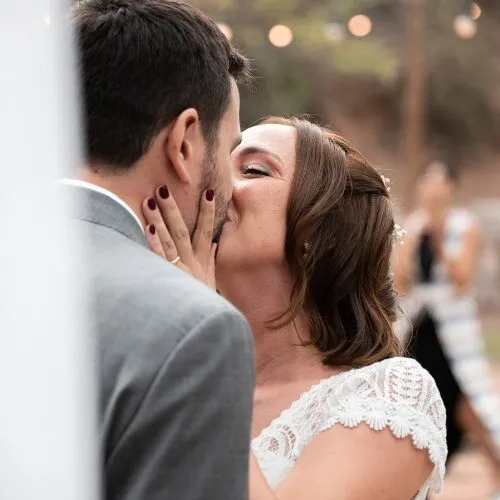 Novios compartiendo su primer beso durante la ceremonia de boda.