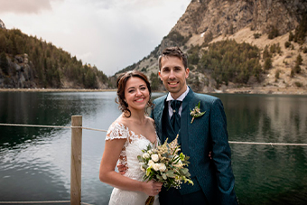Novios posando junto a un lago tras su boda en los Pirineos
