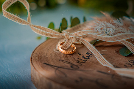 Alianzas de boda atadas con cuerda sobre base de madera personalizada
