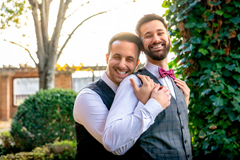 Sesión de postboda con pareja de novios LGTB en jardín al atardecer