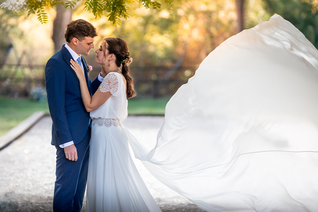 Clara y Manuel en su boda en Huesca, La Pardina del Solano, mirándose con complicidad mientras el velo ondea al viento.