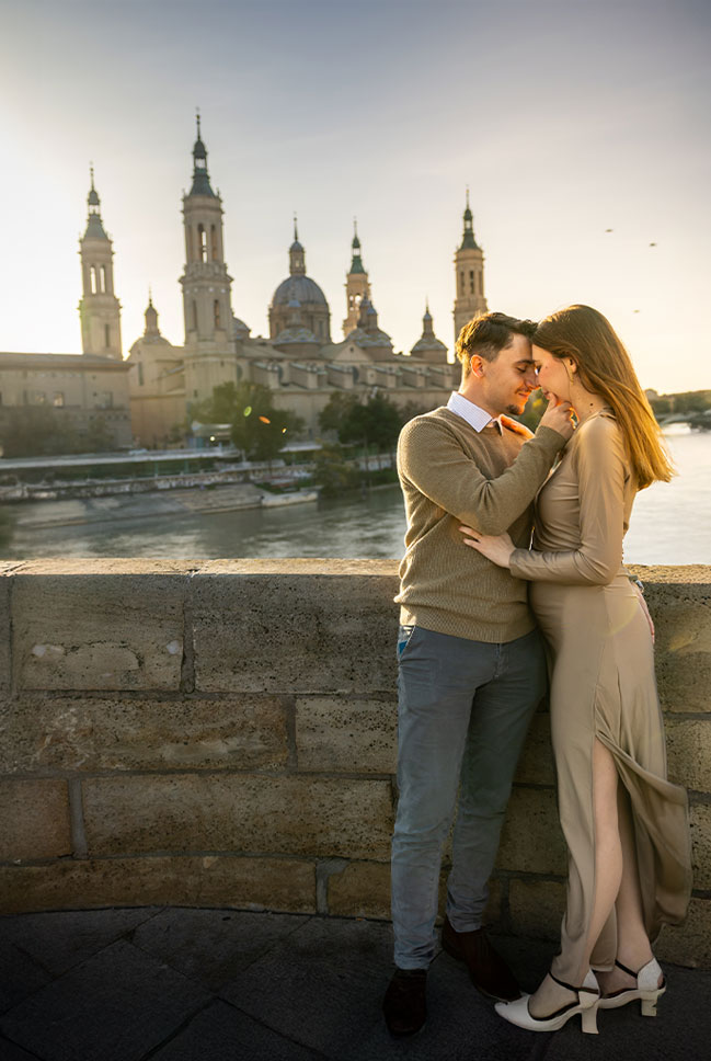 Preboda en Zaragoza de Yaiza y Salomón frente a la Basílica del Pilar al atardecer, con un abrazo romántico junto al río Ebro.