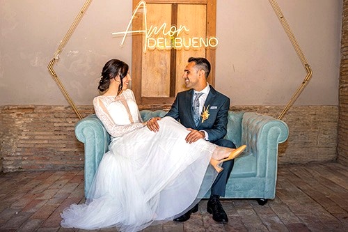 Novios sentados en un sofá decorado en su boda en Barcelona